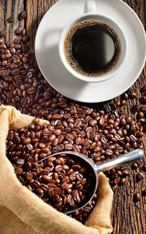 cup of coffee surrounded by coffee beans